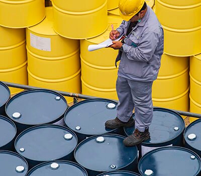 Male worker inspection record drum oil stock barrels yellow vertical or chemical for transportation truck male in the industry.