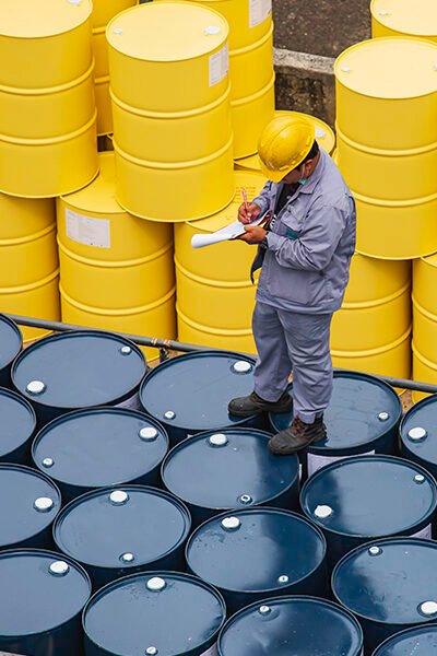 Male worker inspection record drum oil stock barrels yellow vertical or chemical for transportation truck male in the industry.