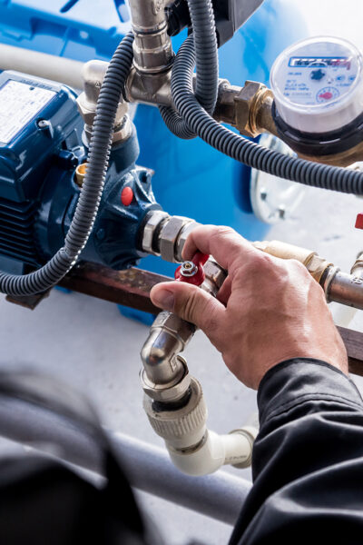 Technician checking water system nodes. Modern Industrial background.