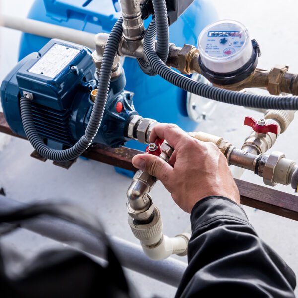 Technician checking water system nodes. Modern Industrial background.