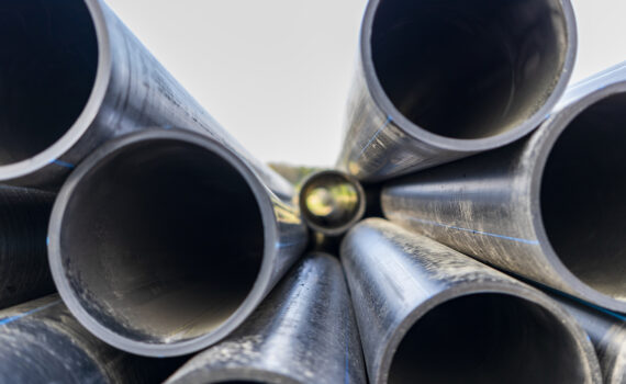 Water pipes for drinking water supply lie on the construction site. Preparation for earthworks for laying an underground pipeline. Modern water supply systems for a residential city