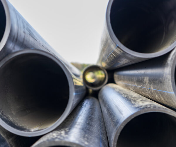 Water pipes for drinking water supply lie on the construction site. Preparation for earthworks for laying an underground pipeline. Modern water supply systems for a residential city