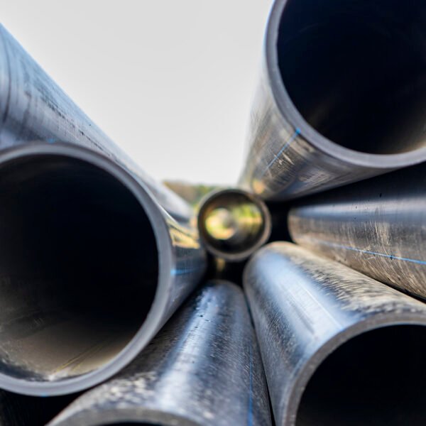 Water pipes for drinking water supply lie on the construction site. Preparation for earthworks for laying an underground pipeline. Modern water supply systems for a residential city