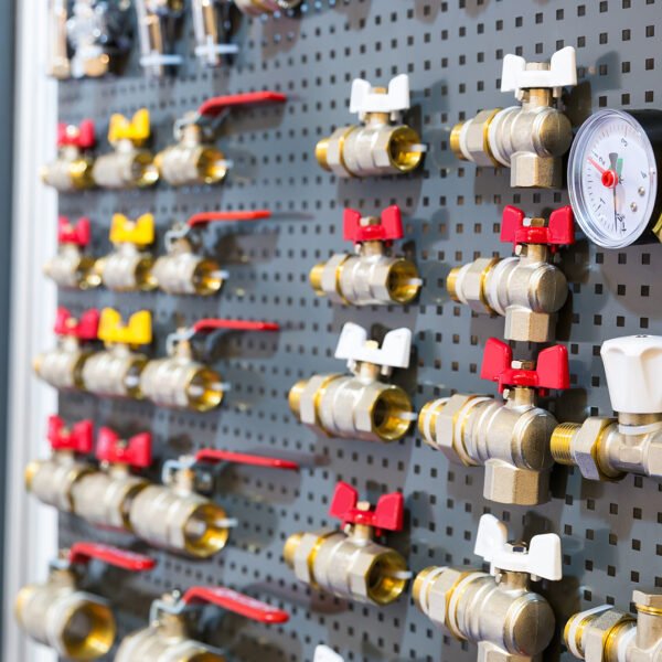 Different valves and other plumbing equipment on the wall